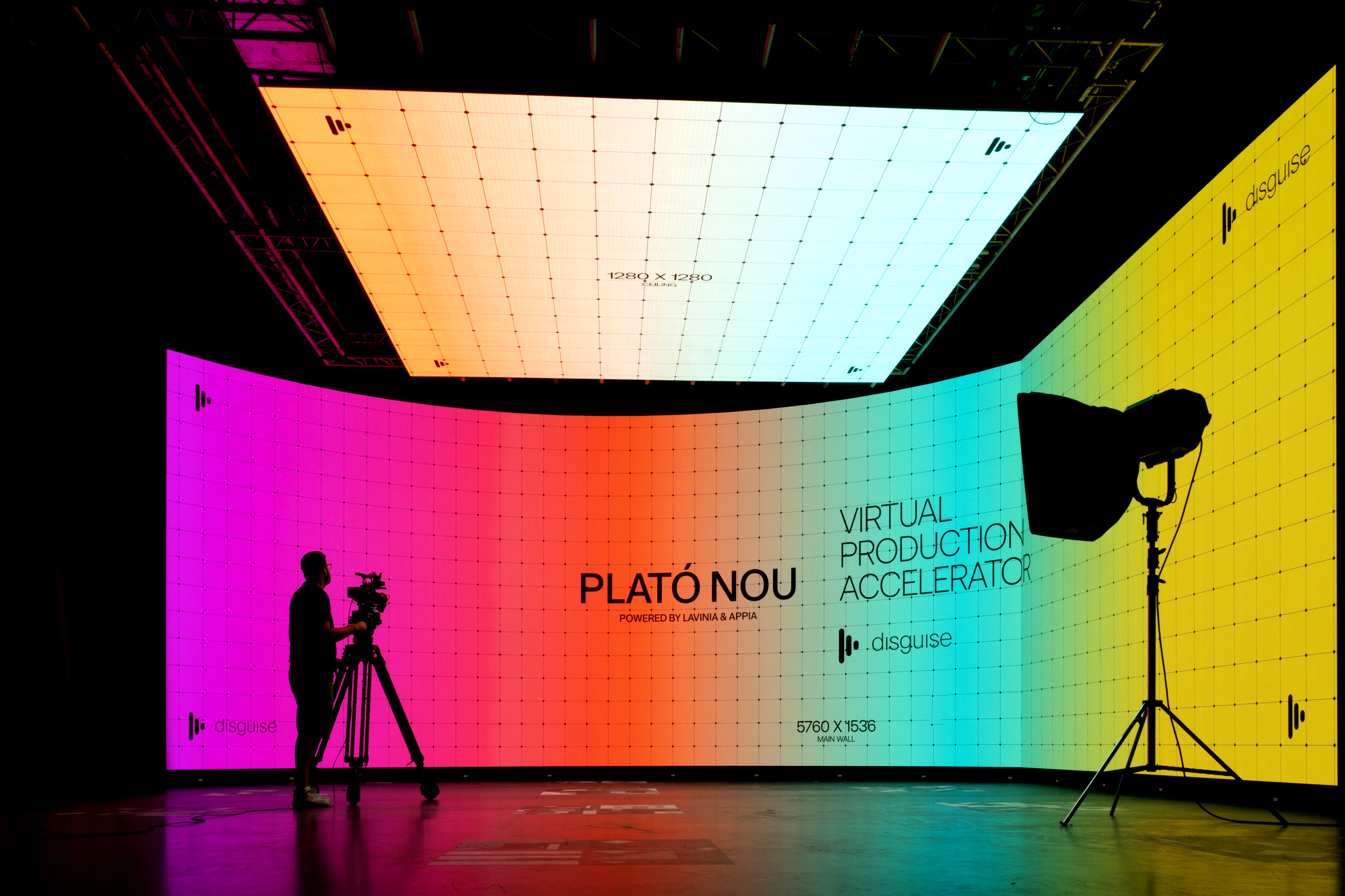 A neon screen displays the disguise, Plato Nou logos